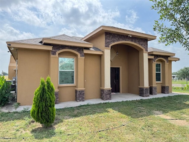 view of front facade featuring stone siding, a front yard, and stucco siding