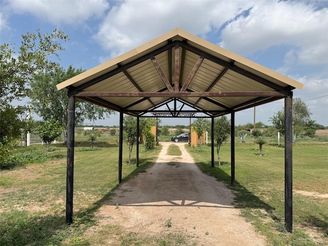 view of parking featuring dirt driveway and a carport