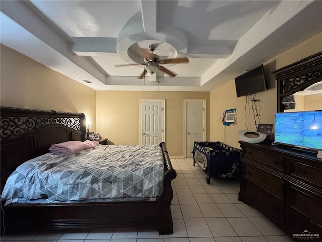 bedroom with visible vents, a ceiling fan, a raised ceiling, and light tile patterned floors