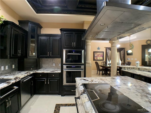 kitchen with decorative columns, island range hood, dark cabinetry, and stainless steel appliances