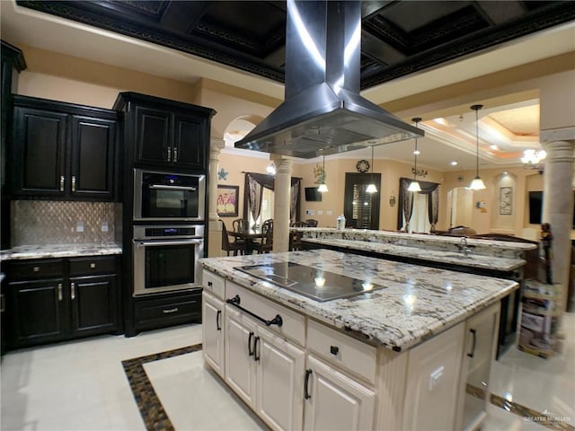 kitchen with dark cabinets, black electric stovetop, and ornate columns