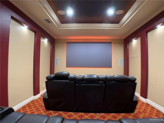 carpeted cinema with baseboards, visible vents, ornamental molding, and a tray ceiling
