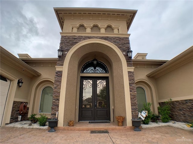 doorway to property featuring stone siding and stucco siding