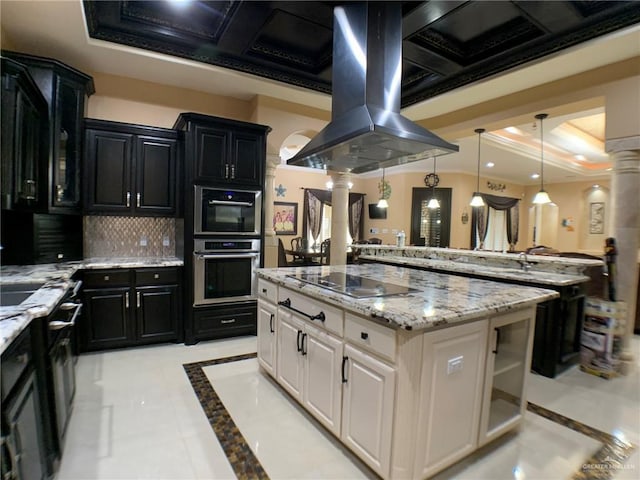 kitchen featuring island range hood, decorative backsplash, dark cabinetry, and black electric cooktop