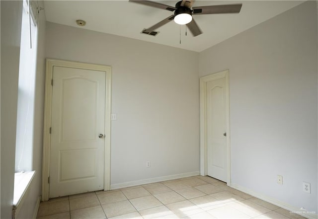 tiled spare room with ceiling fan