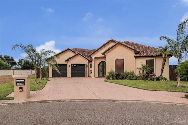 mediterranean / spanish-style house featuring a garage and a front yard