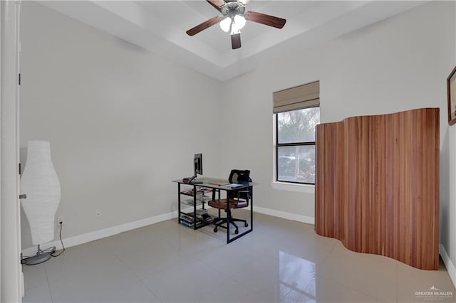 tiled office featuring ceiling fan and a raised ceiling