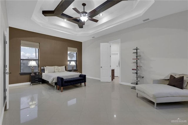 bedroom with a raised ceiling, light tile patterned floors, and ceiling fan