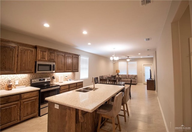 3413 Emory Ave, Mcallen, TX 78504 - kitchen featuring appliances with stainless steel finishes, a sink, backsplash, a kitchen island with sink, and recessed lighting