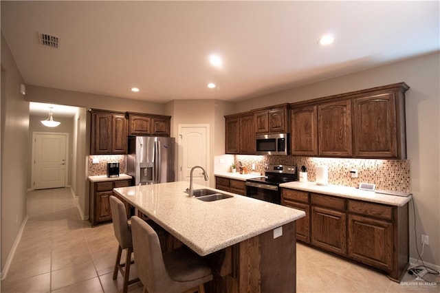 3413 Emory Ave, Mcallen, TX 78504 - kitchen with stainless steel appliances, a sink, backsplash, light countertops, and light tile patterned flooring