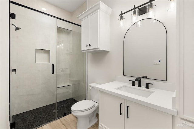 bathroom featuring hardwood / wood-style floors, vanity, an enclosed shower, and toilet