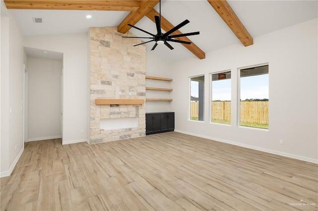 unfurnished living room with vaulted ceiling with beams, ceiling fan, a fireplace, and light hardwood / wood-style floors