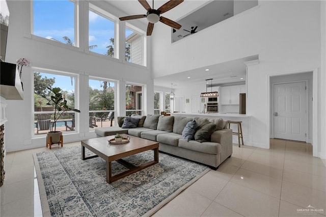 2800 Santa Lydia St, Mission, TX 78572 - living room with a towering ceiling, ceiling fan, light tile patterned flooring, baseboards, and a fireplace