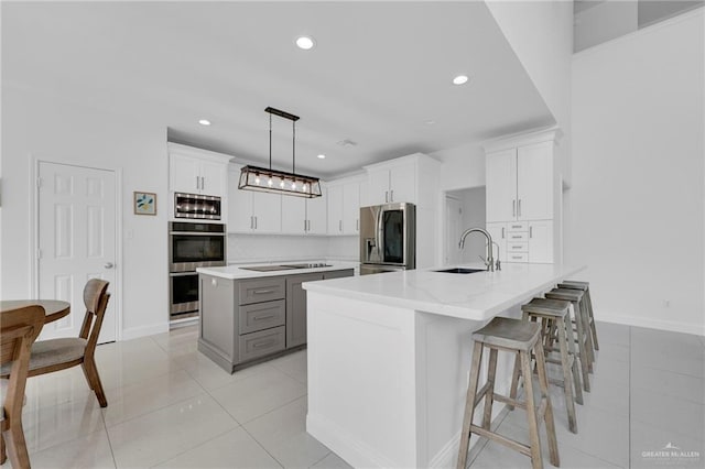 2800 Santa Lydia St, Mission, TX 78572 - kitchen featuring appliances with stainless steel finishes, a sink, a center island, light tile patterned floors, and white cabinetry