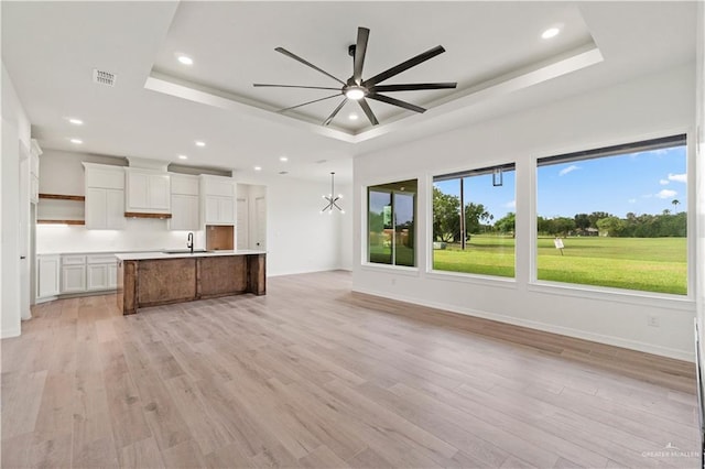 1114 Knotty Pine Ln, Harlingen, TX 78552 - kitchen with a raised ceiling, open floor plan, ceiling fan, an island with sink, and white cabinetry