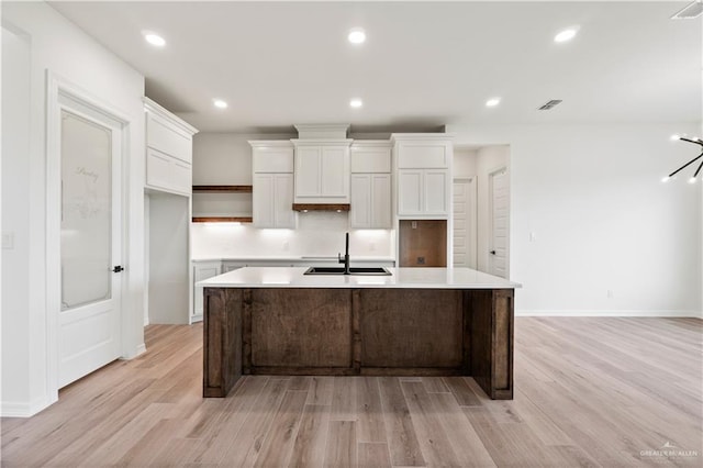 1114 Knotty Pine Ln, Harlingen, TX 78552 - kitchen featuring light wood-type flooring, a kitchen island with sink, white cabinets, and recessed lighting
