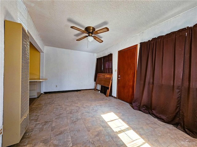 unfurnished bedroom with ceiling fan and a textured ceiling