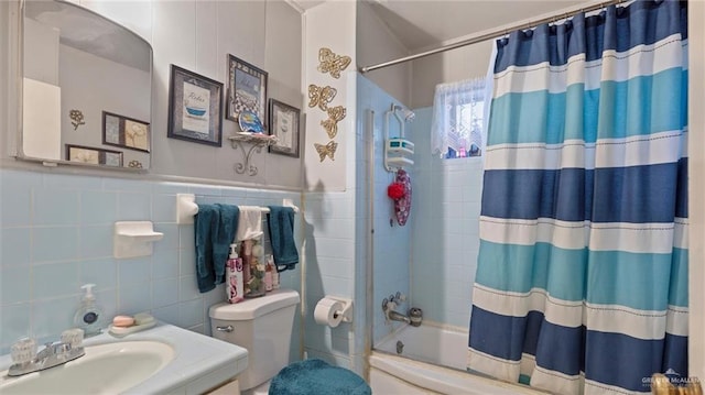 full bathroom with vanity, toilet, shower / bath combo with shower curtain, and tile walls