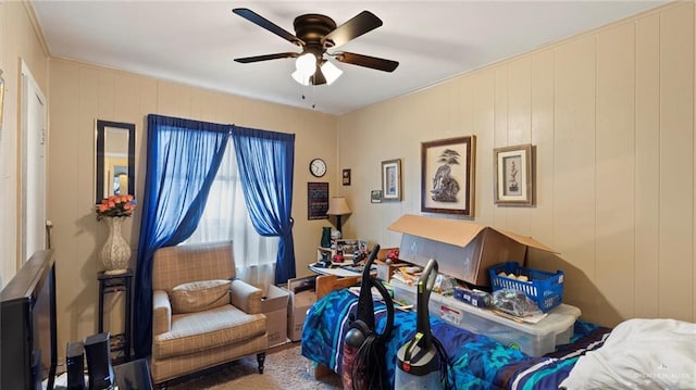 sitting room with ceiling fan and wooden walls