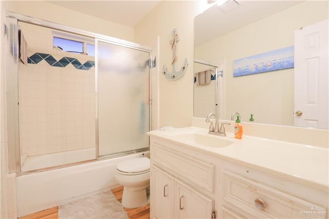 full bathroom featuring vanity, toilet, enclosed tub / shower combo, and wood-type flooring