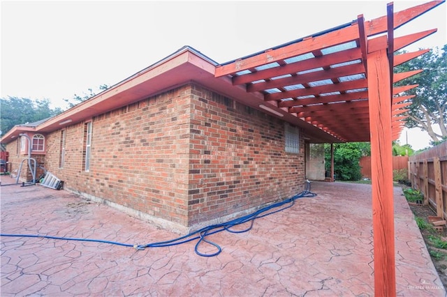 view of side of home featuring a pergola and a patio area