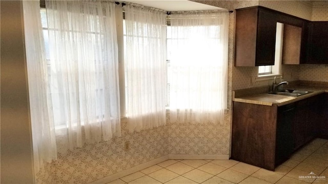 kitchen with dark brown cabinets, sink, and light tile patterned floors