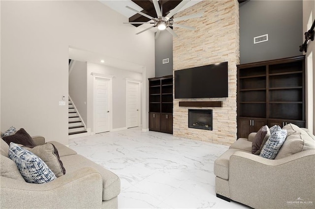 living room with a fireplace, ceiling fan, stairs, visible vents, and marble finish floor