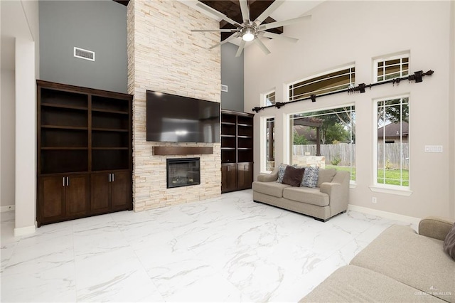 living area with visible vents, baseboards, a fireplace, a ceiling fan, and marble finish floor