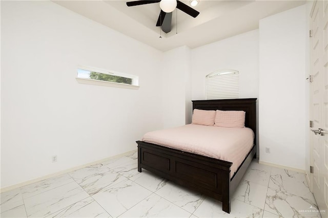 bedroom featuring baseboards, a raised ceiling, a ceiling fan, and marble finish floor
