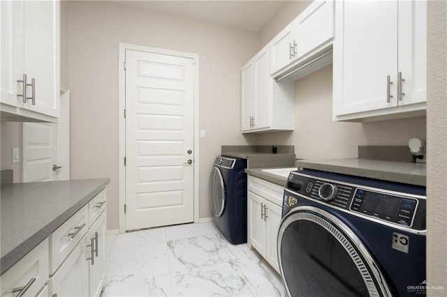 washroom featuring washing machine and clothes dryer, cabinet space, marble finish floor, and baseboards