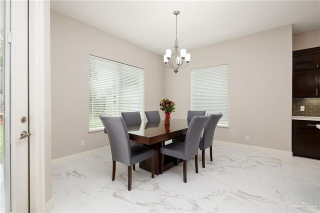dining area with baseboards, an inviting chandelier, and marble finish floor