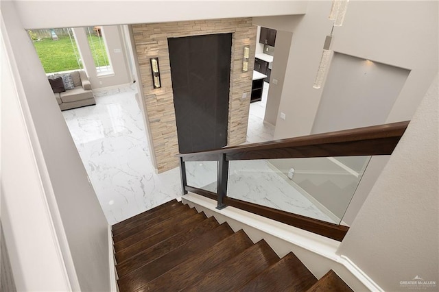 stairway featuring marble finish floor