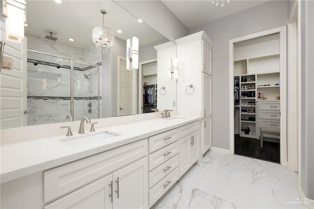 full bath featuring a sink, a marble finish shower, recessed lighting, a spacious closet, and marble finish floor