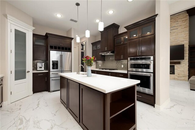 kitchen with appliances with stainless steel finishes, light countertops, marble finish floor, and backsplash