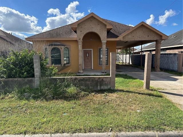 view of front of property with a front yard and a carport