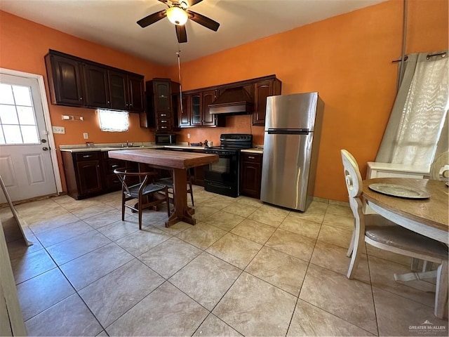 kitchen with ceiling fan, stainless steel fridge, light tile patterned floors, black range with electric cooktop, and dark brown cabinets