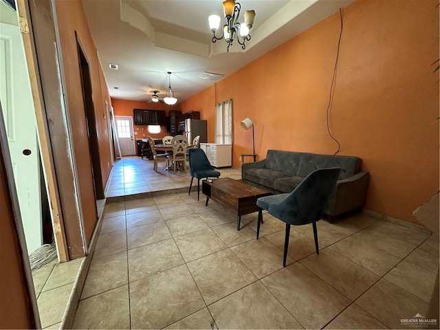 living room with light tile patterned floors and ceiling fan with notable chandelier