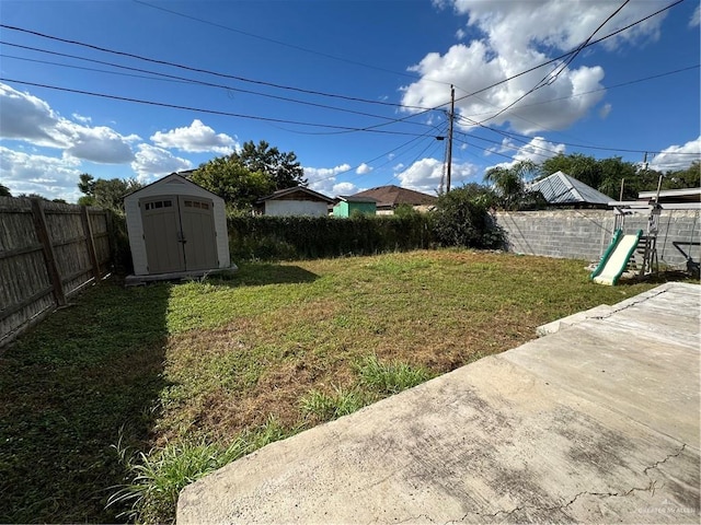 view of yard with a storage unit and a patio