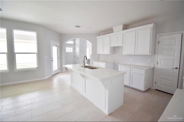 kitchen featuring sink, white cabinetry, and a kitchen island with sink