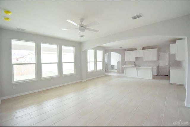 unfurnished living room with ceiling fan and sink