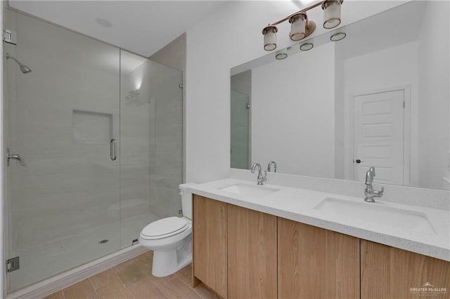 full bathroom with a stall shower, a sink, toilet, and double vanity