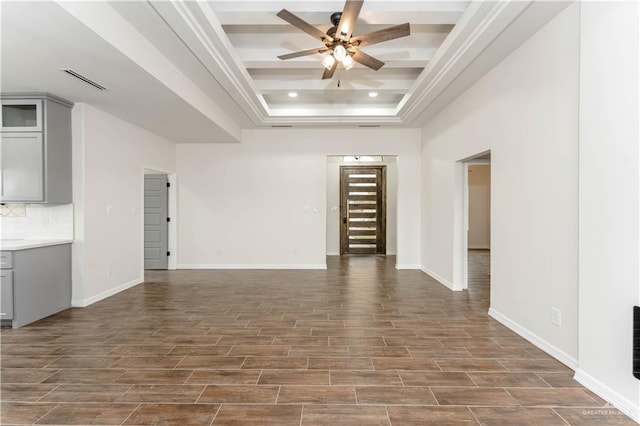 unfurnished living room featuring ceiling fan, a raised ceiling, and dark wood-type flooring