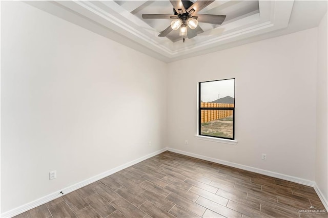 unfurnished room featuring hardwood / wood-style floors, ceiling fan, and a raised ceiling