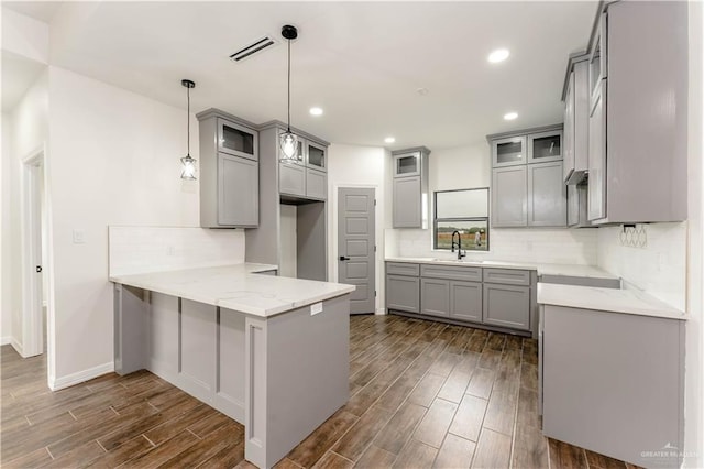 kitchen featuring kitchen peninsula, pendant lighting, and dark hardwood / wood-style floors