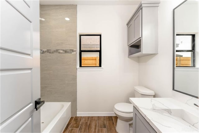 full bathroom with wood-type flooring, vanity, toilet, and tiled shower / bath combo