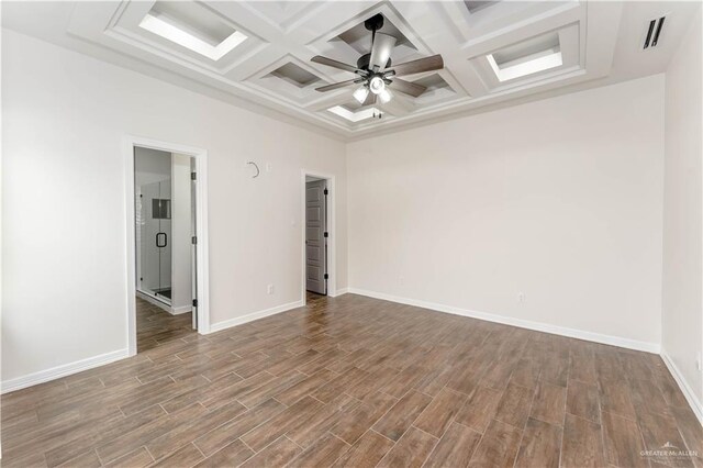 empty room featuring beamed ceiling, hardwood / wood-style flooring, ceiling fan, and coffered ceiling