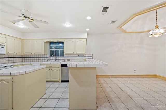 kitchen with decorative backsplash, dishwasher, tile counters, and a kitchen island