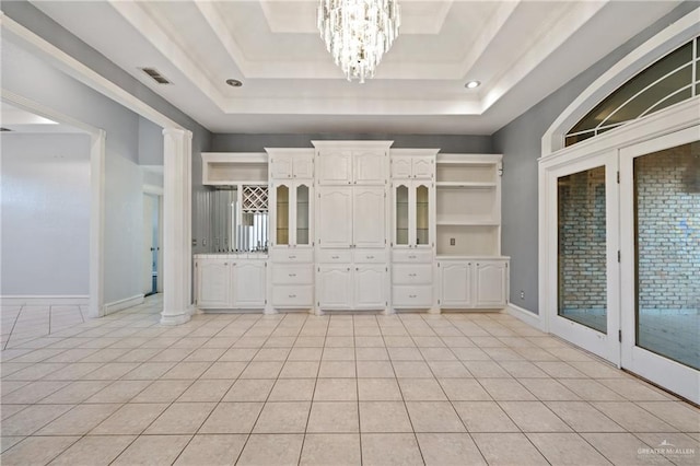 bathroom featuring tile patterned flooring, a notable chandelier, and a raised ceiling