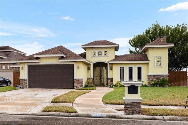 view of front of property with a front yard and a garage