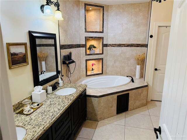 bathroom with tile patterned flooring, vanity, tiled bath, and tile walls